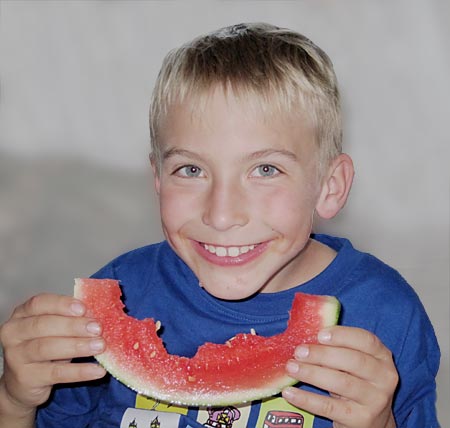 Junge isst Melone